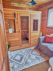 Cabaña de madera con cama y ventana en Wnion Wood Lodge with log burner & sauna in Snowdonia, en Llanfachreth