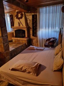 a large bed in a room with a fireplace at Maggie's Traditional home in Pylos