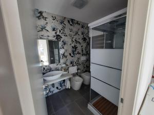 un piccolo bagno con lavandino e servizi igienici di GUEST HOUSE TRA CIELO E MARE a Nettuno
