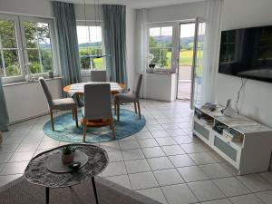 a living room with a table and chairs at Ferienwohnung-Orth-Tor-zum-Sauerland-mit-grosser-Terrasse in Meinerzhagen