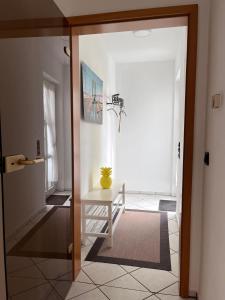 a hallway with a table with a yellow vase on it at Ferienwohnung-Orth-Tor-zum-Sauerland-mit-grosser-Terrasse in Meinerzhagen