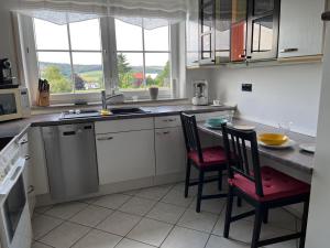 - une cuisine avec 2 chaises et une table dans l'établissement Ferienwohnung-Orth-Tor-zum-Sauerland-mit-grosser-Terrasse, à Meinerzhagen