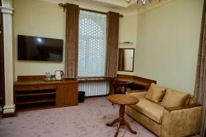 a living room with a couch and a flat screen tv at Sangzor Boutique Hotel in Samarkand