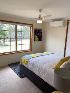 1 dormitorio con cama, mesa y ventanas en Severnview, en Ballandean