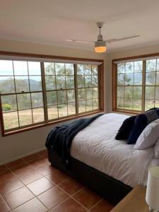 a bedroom with a large bed in a room with windows at Severnview in Ballandean