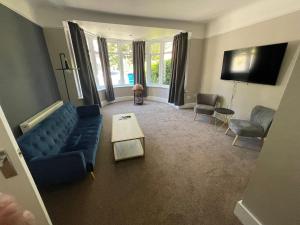 a living room with a blue couch and a table at Bayside GuestHouse in Bournemouth