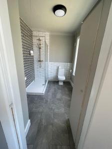 a bathroom with a toilet and a walk in shower at Bayside GuestHouse in Bournemouth