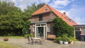 a house with a table and chairs in front of it at B&B Verwoldsehof 'Op de deel' in Laren