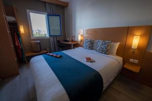 a bedroom with a large bed with a book on it at Hôtel La Perle de Mogador in Essaouira +47 photos