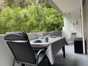 een tafel en stoelen op een balkon met een groot raam bij Ferienwohnung Memory in Bad Harzburg