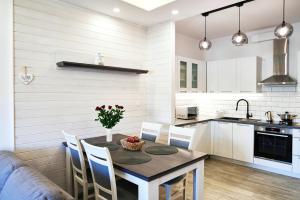 a kitchen and dining room with a table and chairs at Komfort & Garaż Apartment - Samozameldowanie in Suwałki