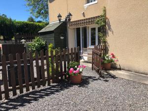 a fence with potted plants in front of a house at Le Grand Camelia in Saint-Martin-dʼAubigny