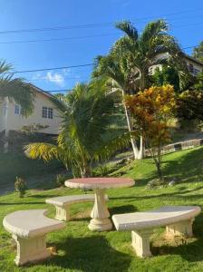 a picnic table and two benches in a yard at Homely environment ideal for a home away from home in Gros Islet