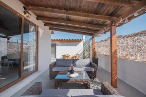 a patio with a couch and a table and chairs at Cozy Loft with Private Terrace in Kremasti
