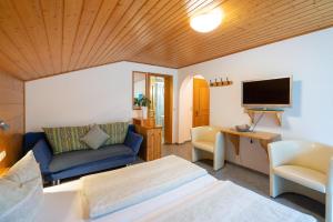 a living room with a bed and a tv at Gästehaus Fitsch - Ferienwohnung in Silbertal in Silbertal