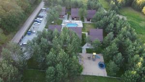 an aerial view of a house with a pool and trees at Sosnowe Wzgórze in Pasym