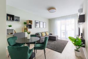 - un salon avec une table, des chaises et un canapé dans l'établissement Second Home Apartment, à Budapest