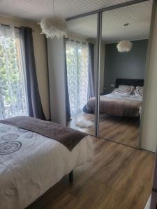 lustro w sypialni z łóżkiem w obiekcie Maison de vacances au cœur de la Cerdagne w mieście Angoustrine