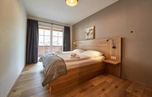 a bedroom with a bed with a wooden headboard and a window at Appartement Iglsberg Top 6 in Saalbach-Hinterglemm