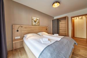 - une chambre avec un grand lit blanc dans l'établissement Appartement Iglsberg Top 6, à Saalbach-Hinterglemm