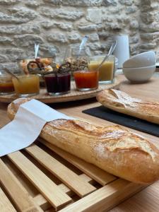 a table with bread and other food on it at Chambre d'hôtes Hôte des Portes Île de Ré in Les Portes