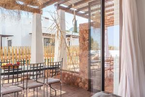 patio con mesa y sillas en el balcón en Las Musarañas - Complejo Rural, en Rodalquilar