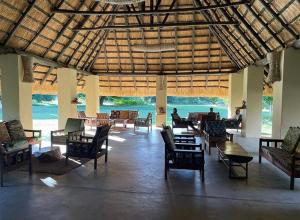 a large room with chairs and tables in a building at Marula Lodge in Mfuwe