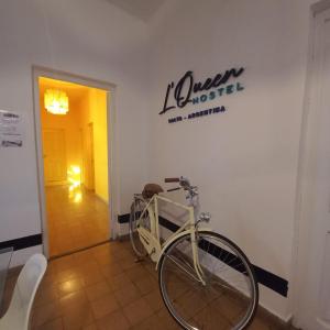 ein Fahrrad parkt in einem Raum mit einem Schild an der Wand in der Unterkunft Hostel LQueen 1 in Salta