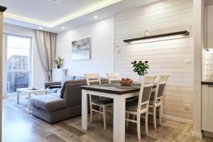 a living room with a table and a couch at Komfort & Garaż Apartment - Samozameldowanie in Suwałki