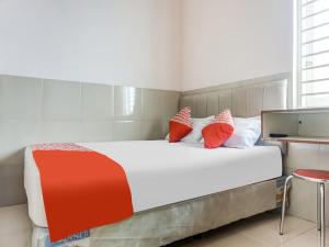 En eller flere senge i et værelse på OYO 91316 Hh Guest House Makassar