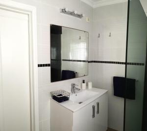 ein weißes Badezimmer mit Waschbecken und Spiegel in der Unterkunft Luisan Guanarteme in Las Palmas de Gran Canaria