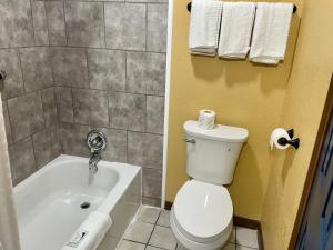 een badkamer met een wit toilet en een bad bij Super 6 Inn in Carencro