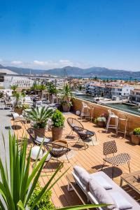 a patio with chairs and tables and a view of a city at Hotel Port Salins by Pierre & Vacances in Empuriabrava