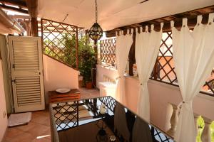 a balcony with white curtains and a table at Appartamenti via Lombardo in Giardini Naxos