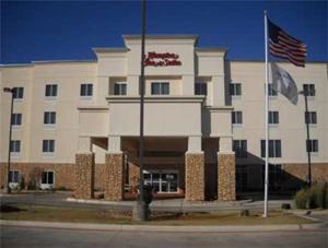 un grand bâtiment blanc avec un drapeau devant lui dans l'établissement Hampton Inn & Suites Lubbock, à Lubbock