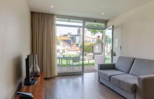 ein Wohnzimmer mit einer Couch und einer Glasschiebetür in der Unterkunft Oca Flores Hotel Boutique in Porto