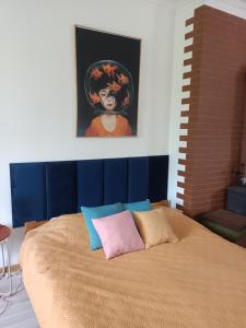 łóżko w pokoju z obrazem na ścianie w obiekcie Studio in Kretomino w Koszalinie