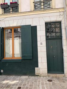 - un bâtiment doté de portes et de fenêtres vertes dans l'établissement Duplex de charme Orléans hypercentre Cathédrale-Parking possible, à Orléans