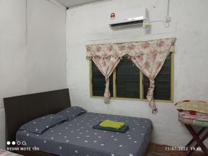 a small bedroom with a bed and a window at Homestay Tok Abah Kuala Rompin 1 Bilik Tidur in Kuala Rompin