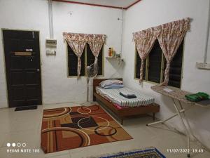 a room with a bed and a table and windows at Homestay Tok Abah Kuala Rompin 1 Bilik Tidur in Kuala Rompin