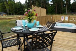 a black table with chairs and a vase of flowers at Hollicarrs Holiday Park - Hares Leap in Riccall