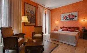 L'Agora Hotel في بوكايرينت: غرفة فندقية بسرير وطاولة وكراسي