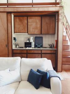 a living room with a white couch and a kitchen at Palácio da Quinta da Portela IV in Coimbra