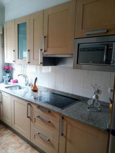 kuchnia ze zlewem i kuchenką mikrofalową w obiekcie Piso de 4 habitaciones w mieście O Grove