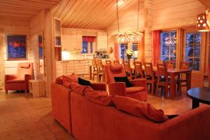 a living room with couches and a table and chairs at Vuosselin Kruunu in Ruka