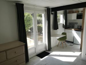 uma cozinha com uma janela e uma mesa com uma cadeira em Studio au calme vue sur garlaban em Roquevaire