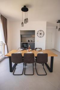 a dining room table with chairs and a clock on the wall at Vertmont Villa in Sveti Stefan