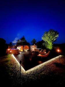 eine nächtliche Ansicht eines Hauses mit Beleuchtung in der Unterkunft FARIE Mazury Dom na wyłączność dla 20 osób z Basenem, Sauną i Jacuzzi in Faryny