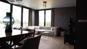 a living room with a couch and a table at Hotel Biesbosch in Drimmelen