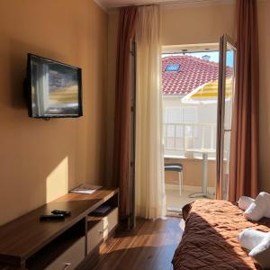 a hotel room with a bed and a tv and a window at Villa Gradina in Baška Voda